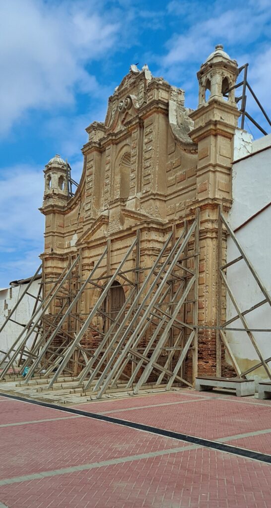 Photo of a church facade in Lambayeque, propped up by scaffolding